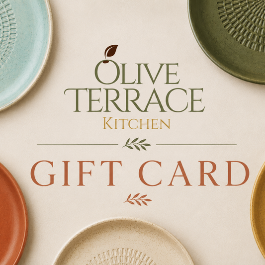 Olive Terrace Kitchen gift card design with the text 'OLIVE TERRACE KITCHEN GIFT CARD' centered on a warm cream background, surrounded by several textured ceramic plates in muted teal, green, terracotta, mustard, and off-white.